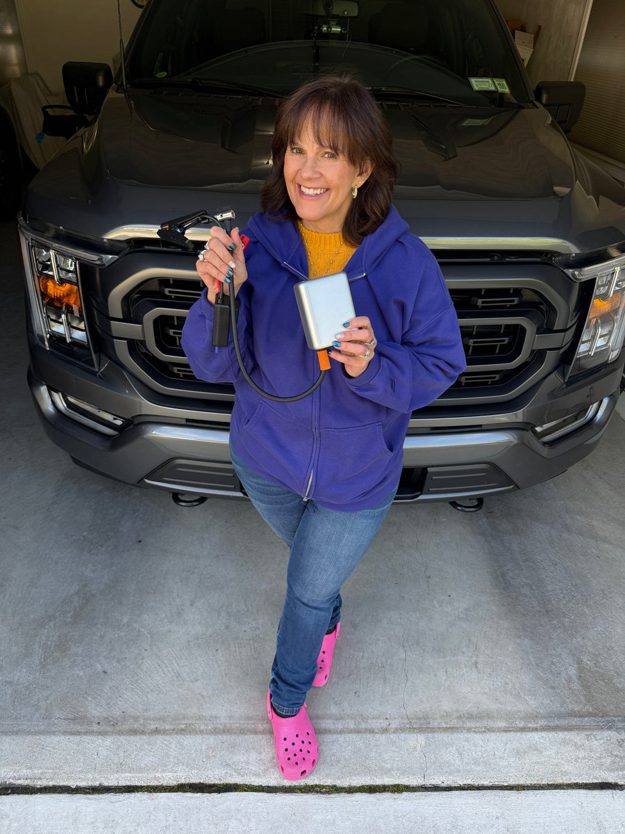 The JumpAir Pro held in one hand, in the garage in front of the truck