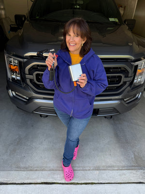 The JumpAir Pro held in one hand, in the garage in front of the truck