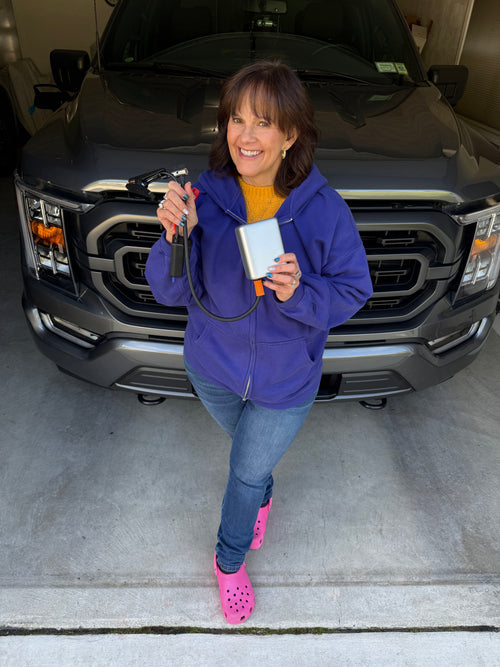 The JumpAir Pro held in one hand, in the garage in front of the truck